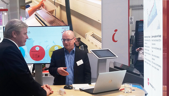 Geschäftsleiter Kamillo Kluth spricht am ABAKUS Messestand mit dem Minister des Bundeslandes Niedersachsen, Dr. Bernd Althusmann, über SEO